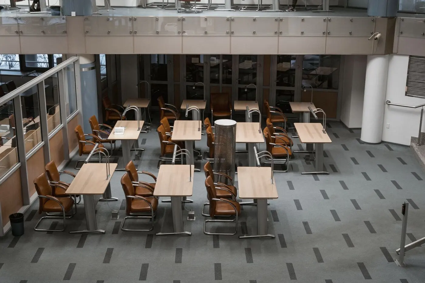 Stock photo of an empty open-plan office with rows of tables and chairs
